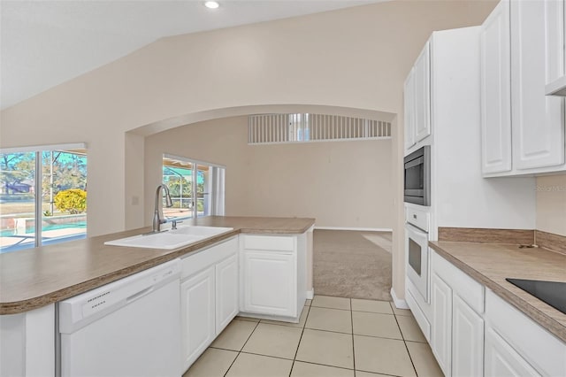 kitchen with white appliances, sink, white cabinetry, lofted ceiling, and light tile patterned flooring