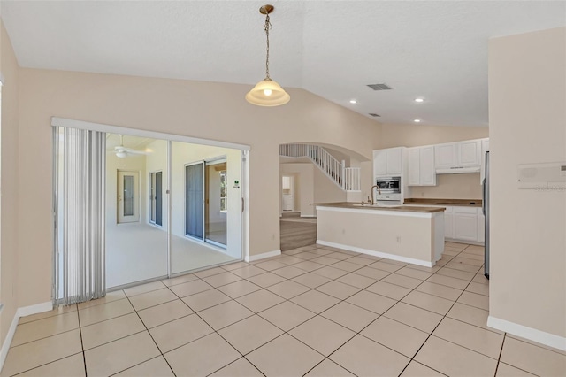 kitchen with pendant lighting, vaulted ceiling, ceiling fan, appliances with stainless steel finishes, and white cabinetry