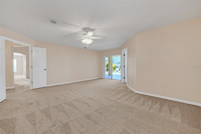 carpeted spare room with ceiling fan and a textured ceiling