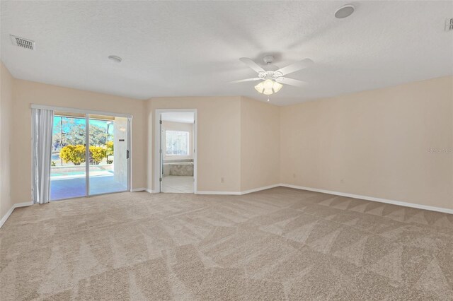 spare room with light carpet, a textured ceiling, and ceiling fan