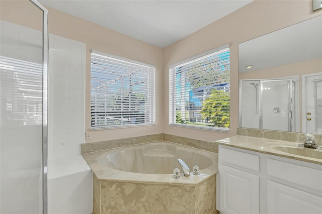 bathroom with vanity and shower with separate bathtub