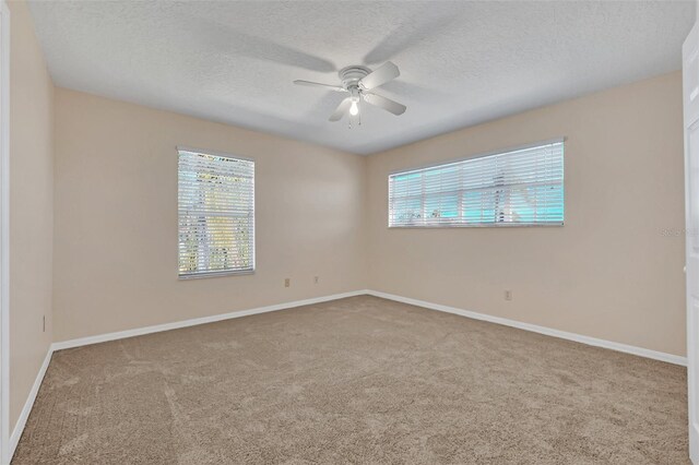 spare room featuring ceiling fan, carpet floors, and a textured ceiling