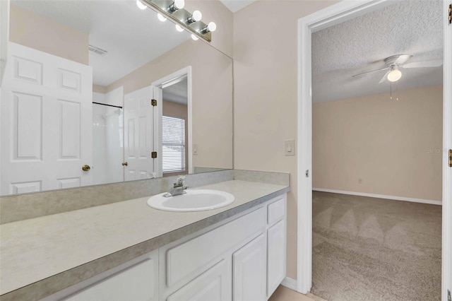 bathroom featuring vanity, a shower, a textured ceiling, and ceiling fan