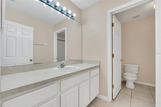 bathroom featuring tile patterned floors, vanity, and toilet