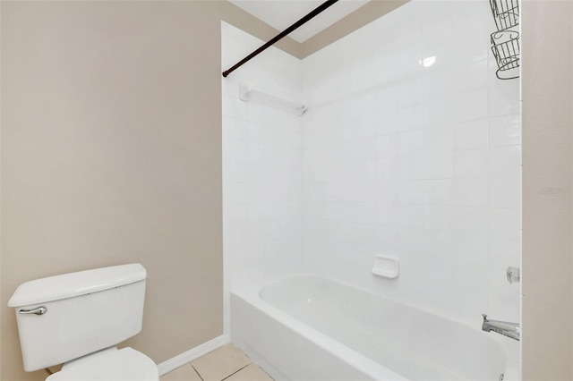 bathroom with tile patterned flooring, tiled shower / bath combo, and toilet