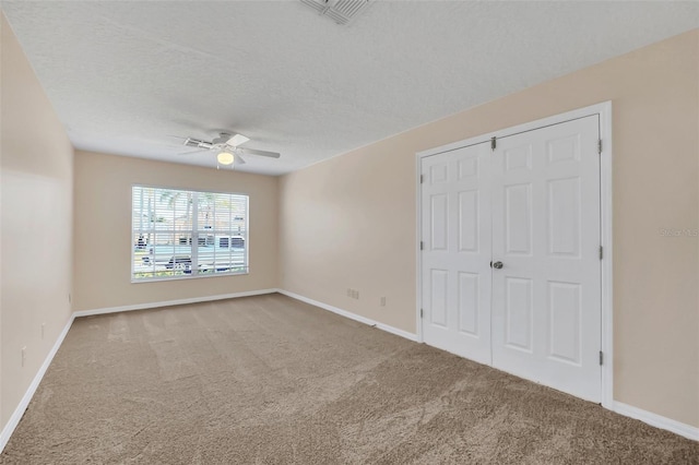 unfurnished bedroom with ceiling fan, carpet floors, and a textured ceiling