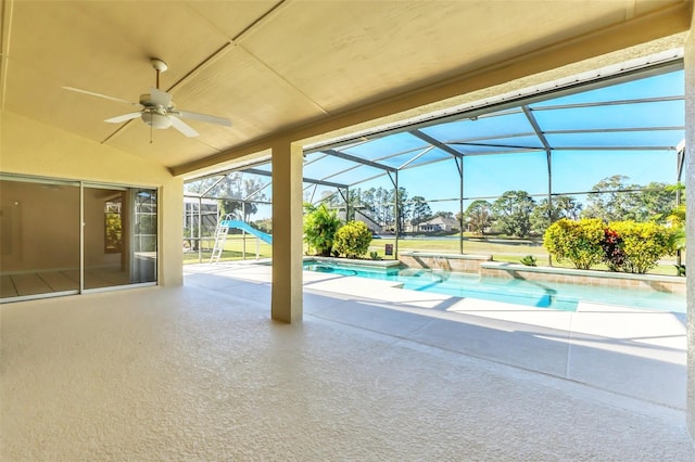 view of pool featuring a patio, glass enclosure, and ceiling fan