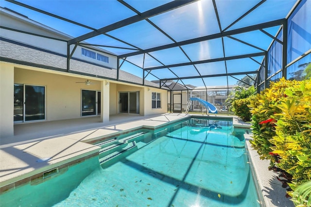 view of pool featuring glass enclosure and a water slide