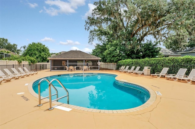 view of swimming pool with a patio area and a sunroom