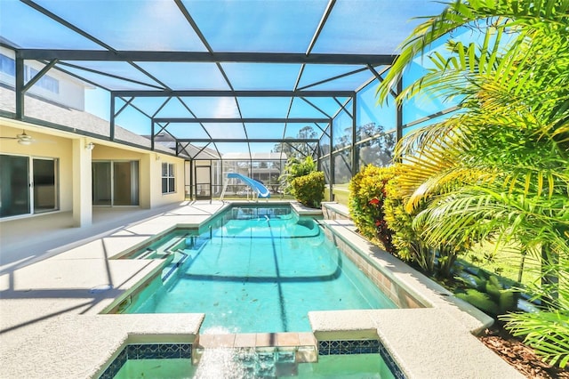 view of pool with a lanai, an in ground hot tub, a water slide, and a patio