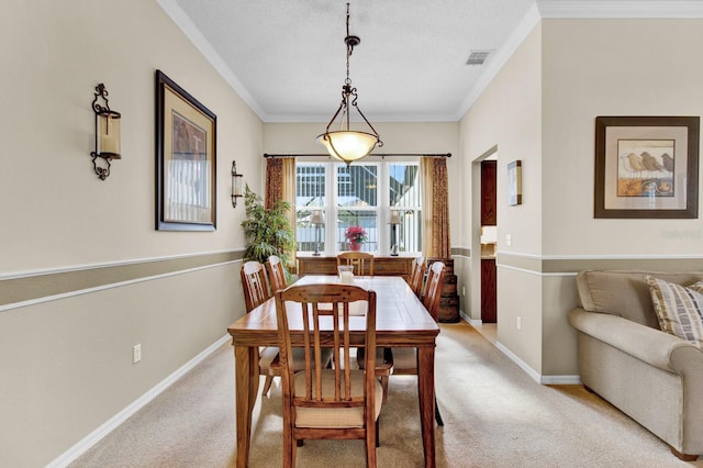 carpeted dining space with a textured ceiling and crown molding