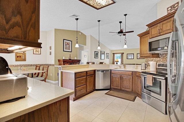 kitchen with ceiling fan, sink, high vaulted ceiling, kitchen peninsula, and appliances with stainless steel finishes