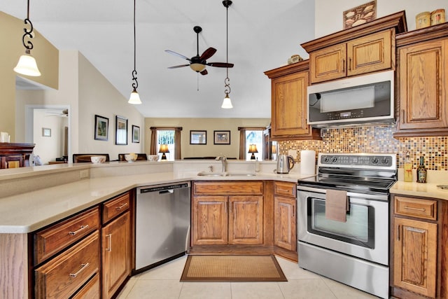 kitchen with pendant lighting, sink, light tile patterned flooring, and stainless steel appliances