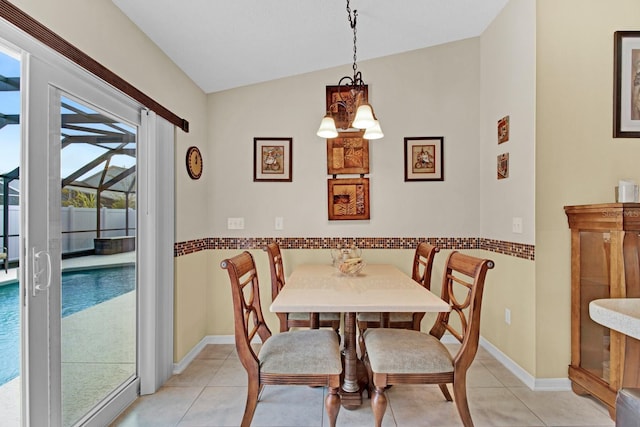 tiled dining space featuring a chandelier and lofted ceiling