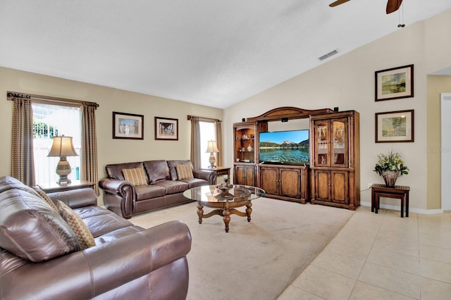 tiled living room with ceiling fan and lofted ceiling