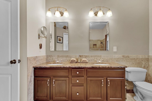 bathroom with vanity, tile walls, and toilet