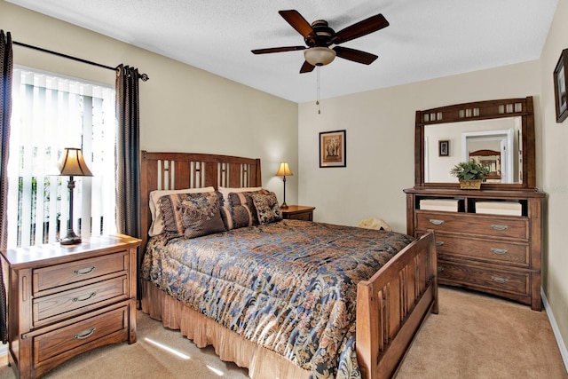 carpeted bedroom featuring ceiling fan and a textured ceiling