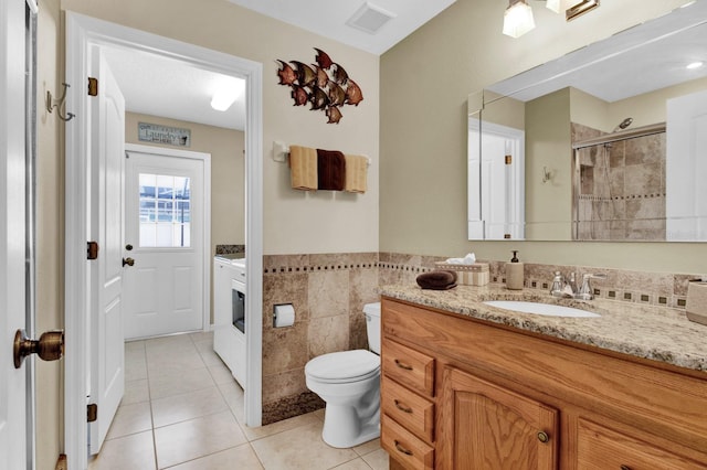 bathroom with vanity, tile patterned flooring, toilet, tile walls, and an enclosed shower