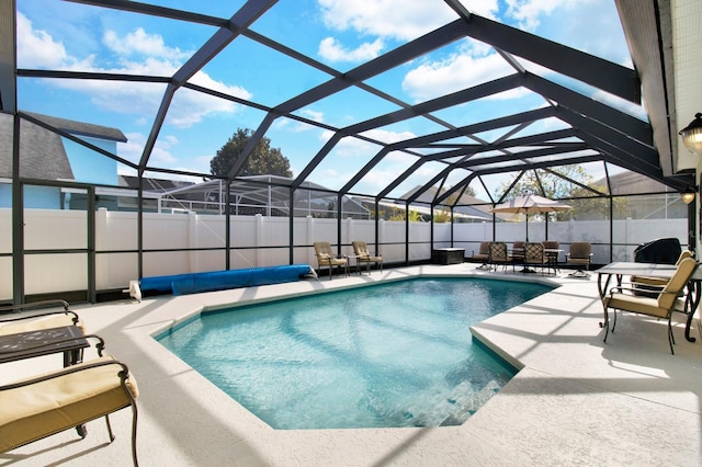 view of swimming pool with a patio area and a lanai