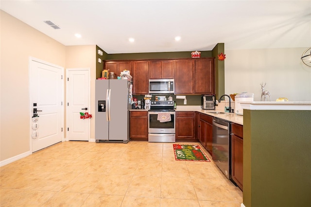 kitchen featuring appliances with stainless steel finishes, light tile patterned floors, and sink