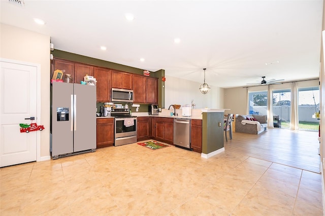 kitchen with hanging light fixtures, kitchen peninsula, light hardwood / wood-style floors, ceiling fan with notable chandelier, and appliances with stainless steel finishes