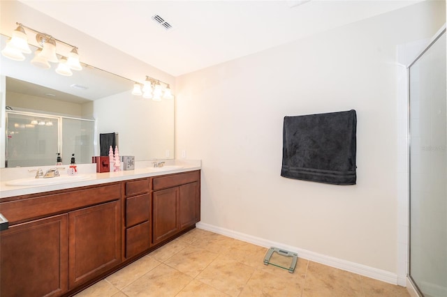 bathroom featuring tile patterned floors, vanity, and a shower with shower door