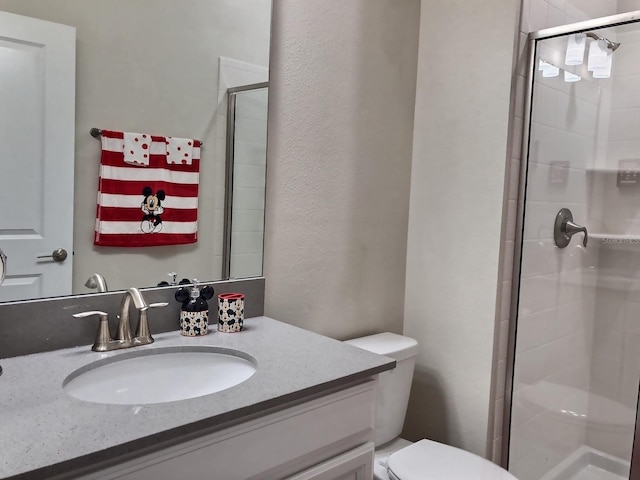 bathroom featuring vanity, toilet, and a shower with door