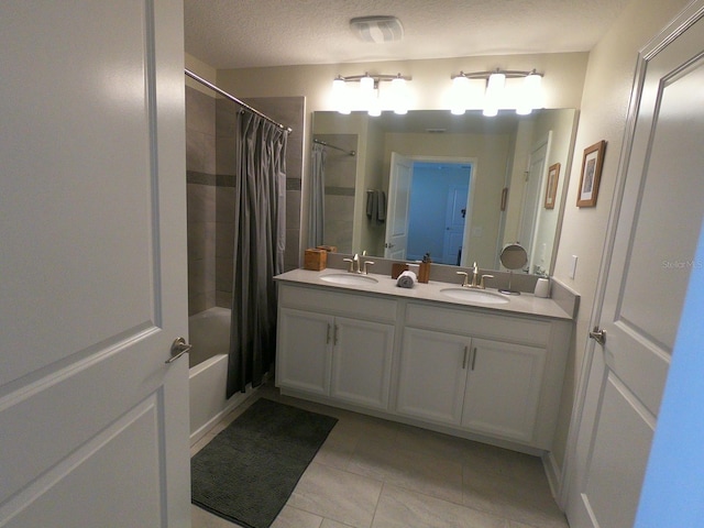 bathroom with vanity, a textured ceiling, and shower / bath combo with shower curtain