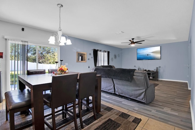 dining room featuring ceiling fan with notable chandelier and hardwood / wood-style flooring