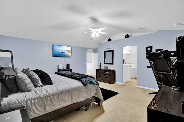 carpeted bedroom featuring a textured ceiling, ensuite bath, ceiling fan, and vaulted ceiling