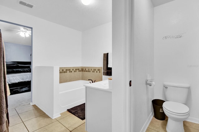 bathroom featuring ceiling fan, tile patterned flooring, toilet, a bathtub, and vanity