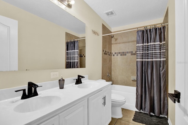 full bathroom featuring vanity, tile patterned floors, shower / bath combination with curtain, toilet, and a textured ceiling