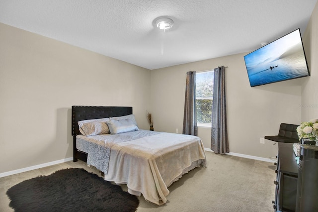 bedroom with light carpet and a textured ceiling