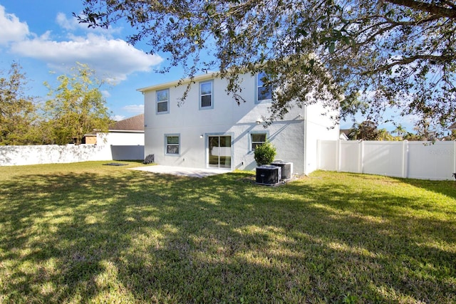 back of property with cooling unit, a patio area, and a lawn