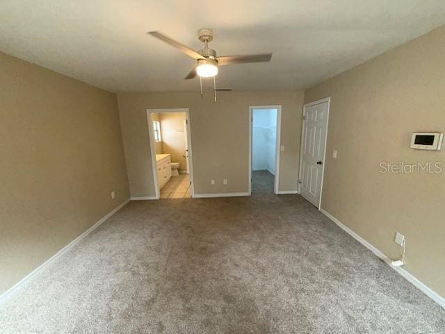 unfurnished bedroom with light carpet, ensuite bath, a closet, and ceiling fan