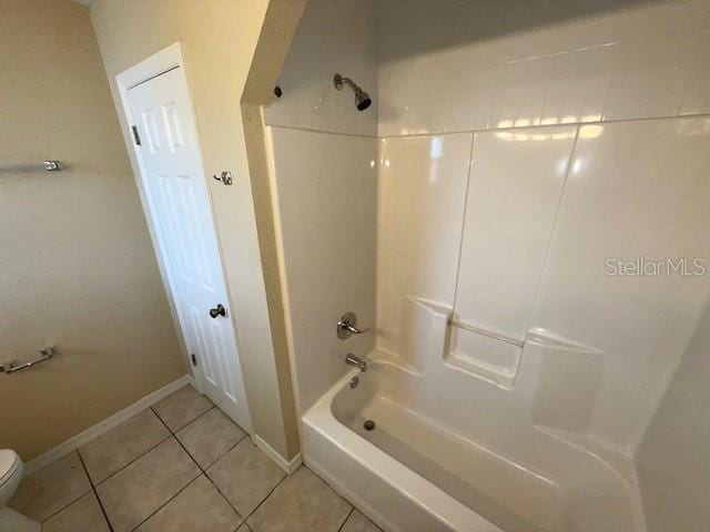 bathroom featuring tile patterned floors, bathtub / shower combination, and toilet