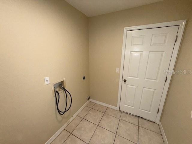 laundry area with electric dryer hookup, hookup for a washing machine, and light tile patterned floors