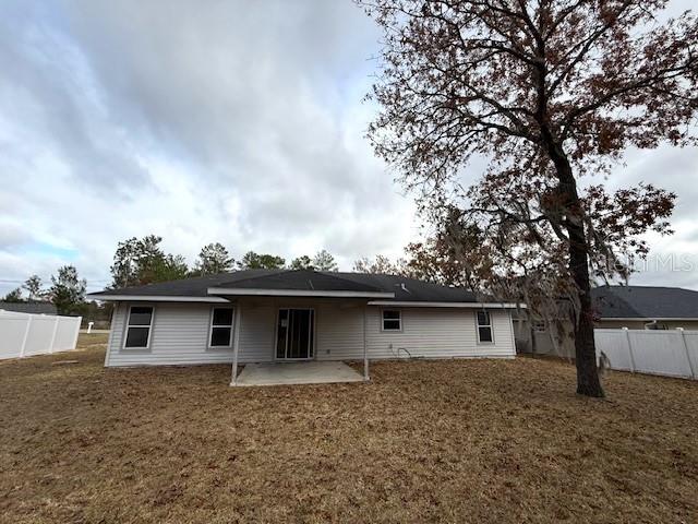 back of house with a yard and a patio area