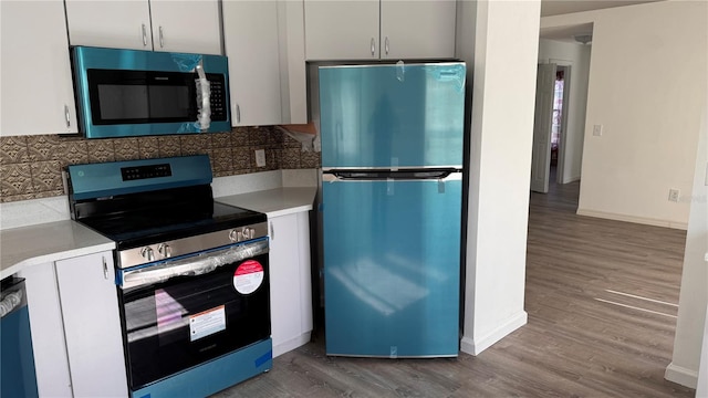 kitchen featuring stainless steel appliances, white cabinetry, and hardwood / wood-style flooring