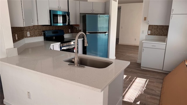 kitchen featuring sink, dark hardwood / wood-style flooring, kitchen peninsula, and stainless steel appliances