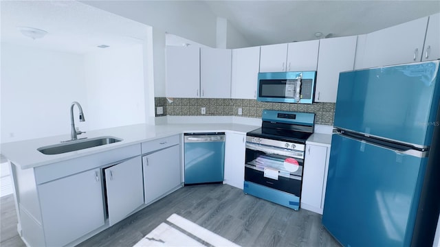 kitchen featuring white cabinets, stainless steel appliances, kitchen peninsula, and sink