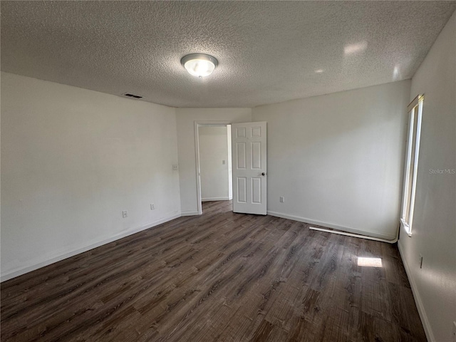 unfurnished room with dark hardwood / wood-style floors and a textured ceiling