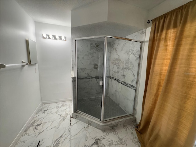 bathroom with a textured ceiling and tiled shower