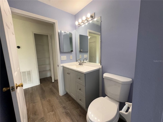 bathroom with hardwood / wood-style flooring, vanity, and toilet