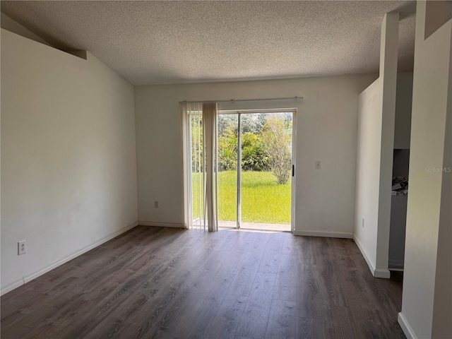 empty room with dark hardwood / wood-style flooring and a textured ceiling