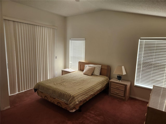 bedroom featuring dark carpet, a textured ceiling, and vaulted ceiling