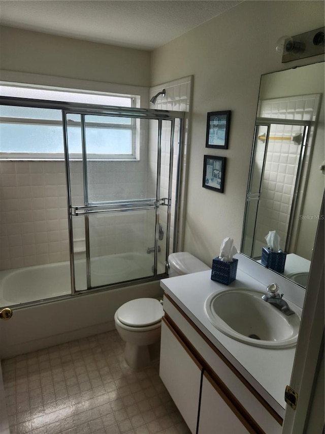 full bathroom featuring a textured ceiling, vanity, toilet, and enclosed tub / shower combo