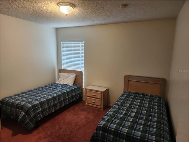 bedroom featuring dark colored carpet and a textured ceiling