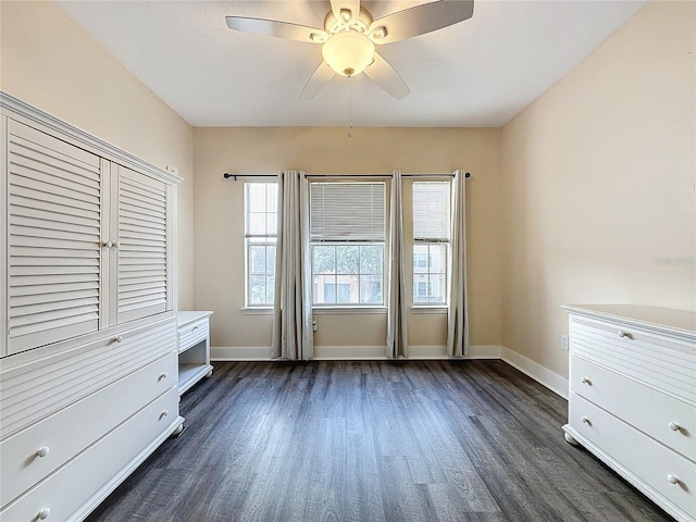 unfurnished bedroom with ceiling fan and dark hardwood / wood-style floors