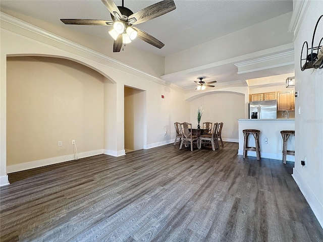 interior space featuring dark hardwood / wood-style flooring, ceiling fan, and ornamental molding